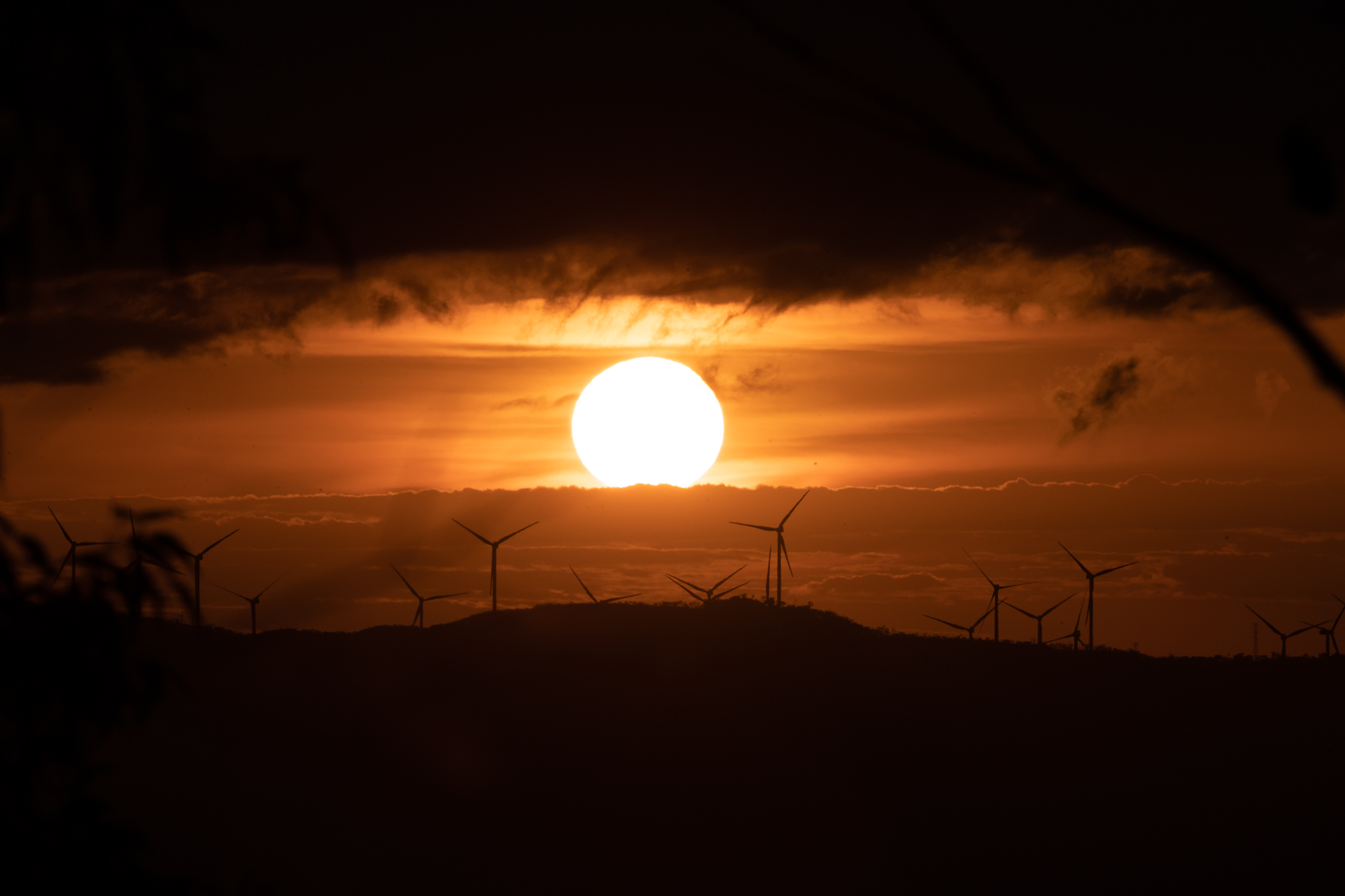 風力発電の山塊に沈む夕陽